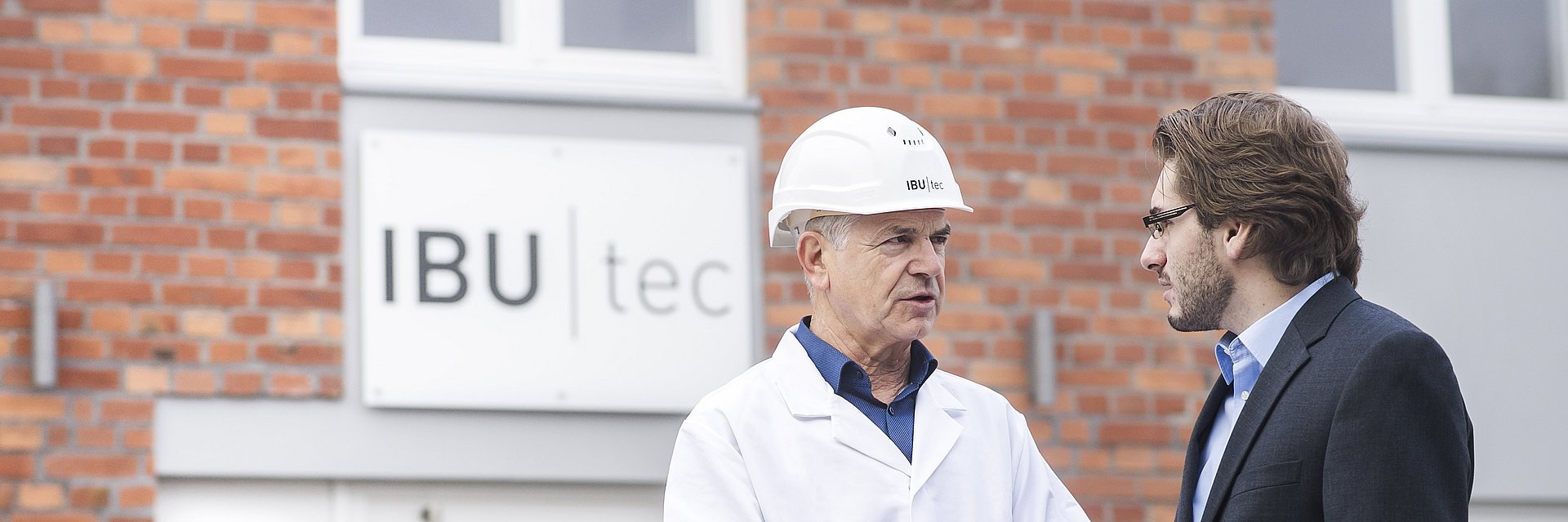 Discussion ou réunion entre le chef de projet et le scientifique de l'IBU-tec devant le bâtiment principal