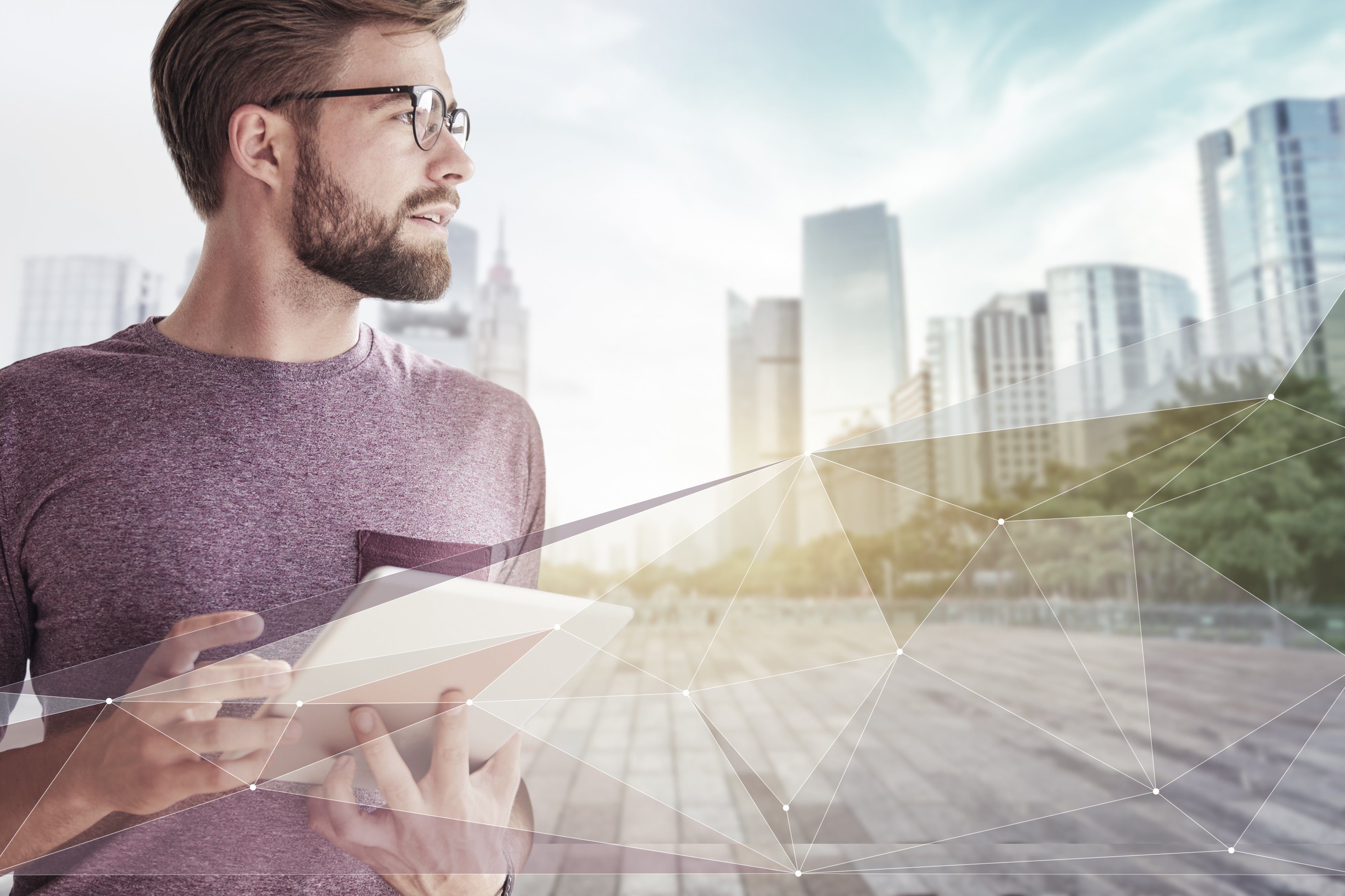 IBU-tec offre une expertise en ingénierie des procédés thermiques et en capacités pour la fabrication en sous-traitance de matériaux chimiques, image avec barbe, tablette et lunettes devant une ville en réseau